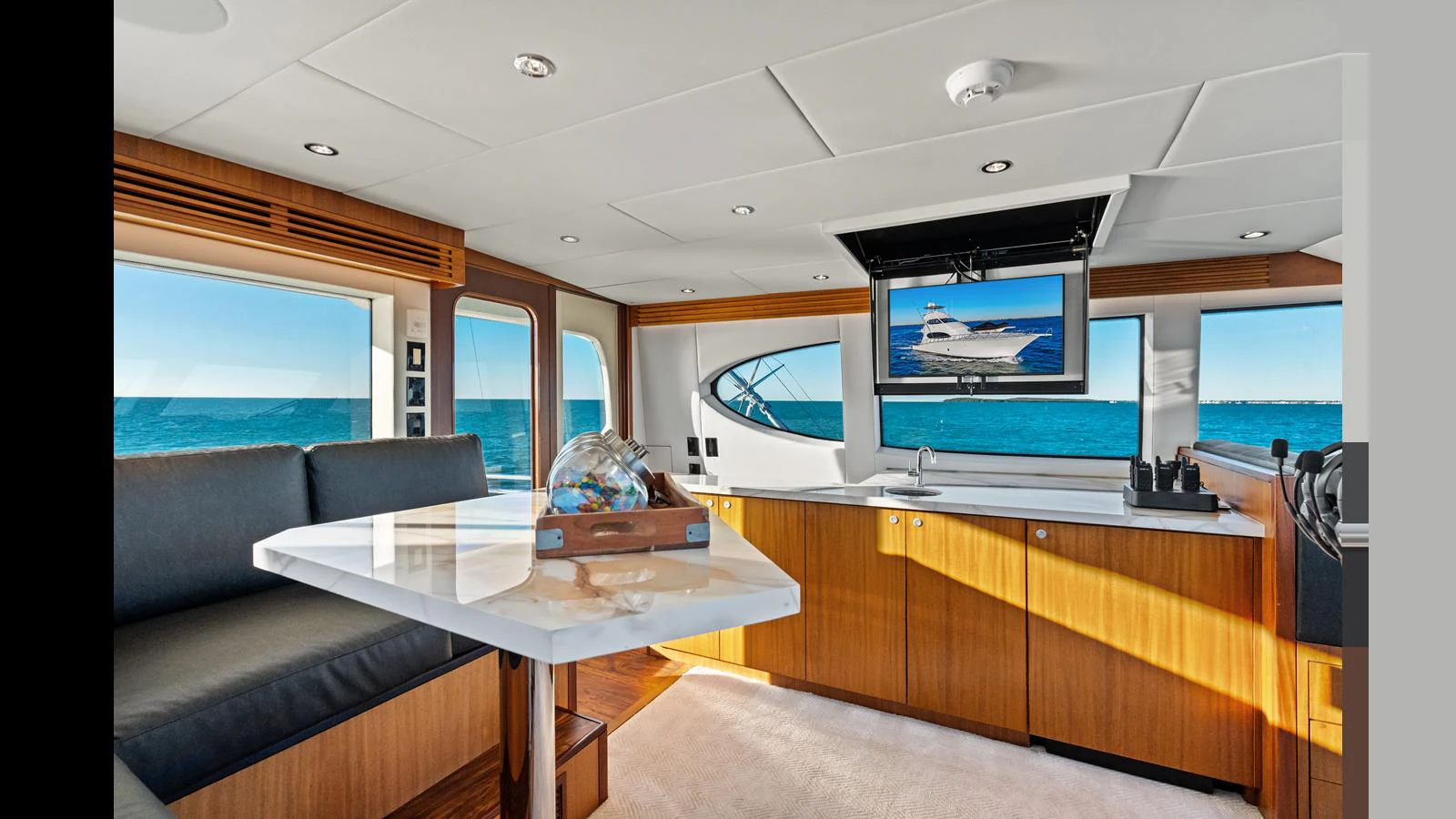 The salon features a luxurious seating area with a marble table and a large window offering stunning ocean views. aboard FIRTH'S CHASM Yacht for Sale