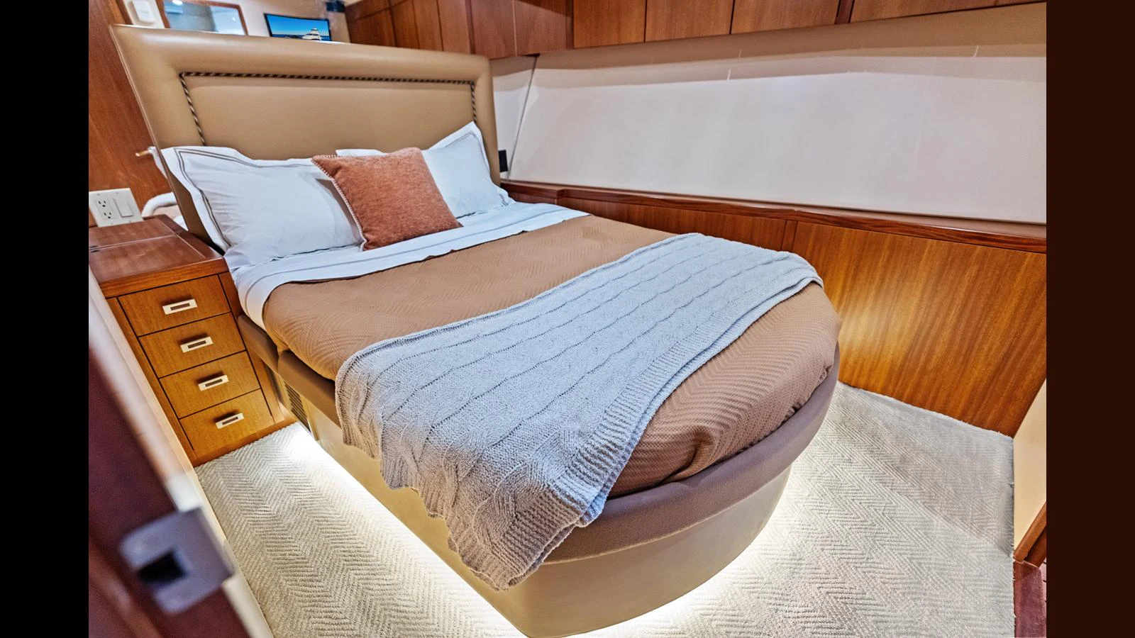 The stateroom features a cozy bed with elegant bedding and warm wood finishes. aboard FIRTH'S CHASM Yacht for Sale
