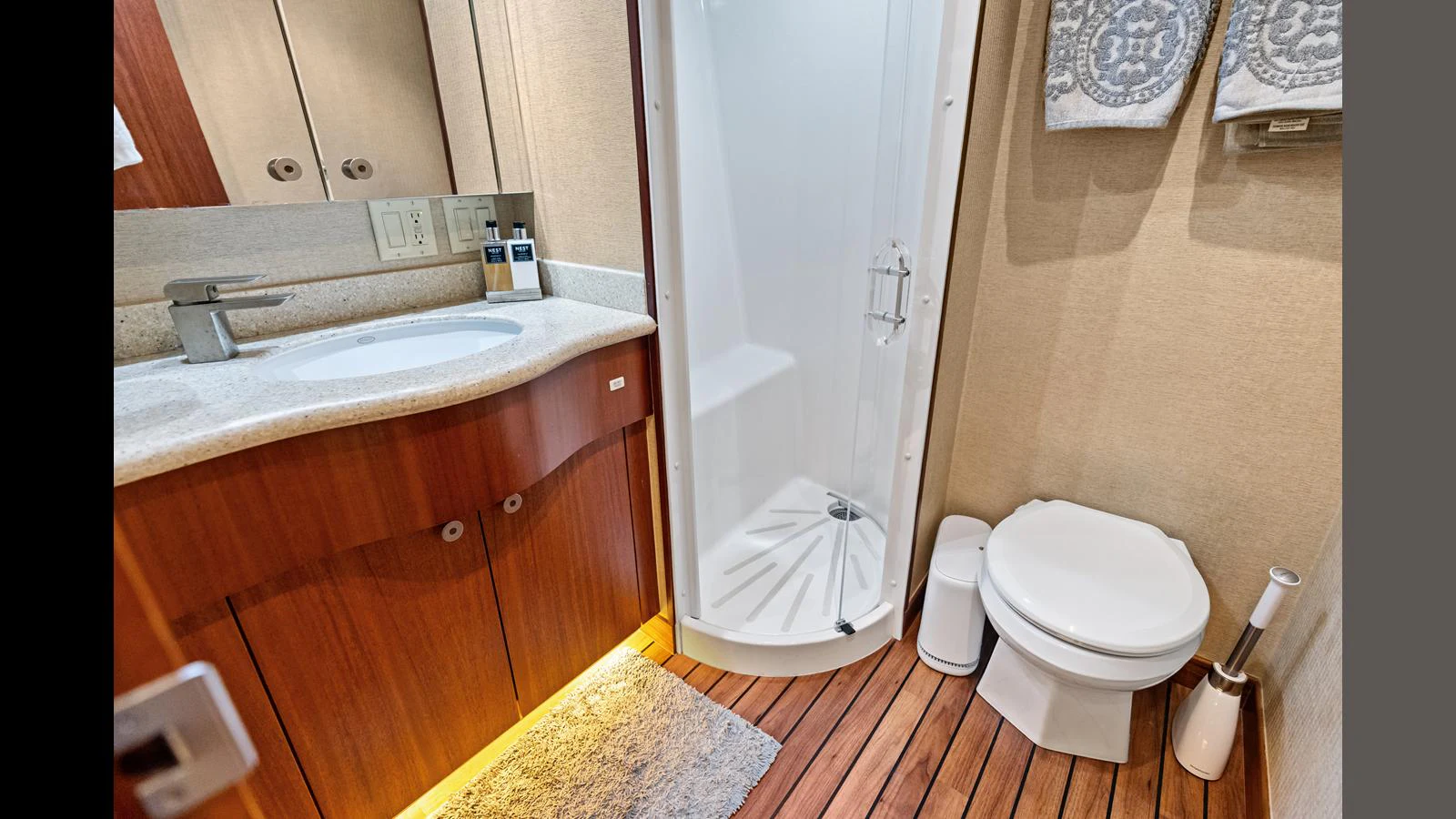 A well-appointed yacht bathroom featuring a shower, sink, and toilet with elegant wood finishes. aboard FIRTH'S CHASM Yacht for Sale