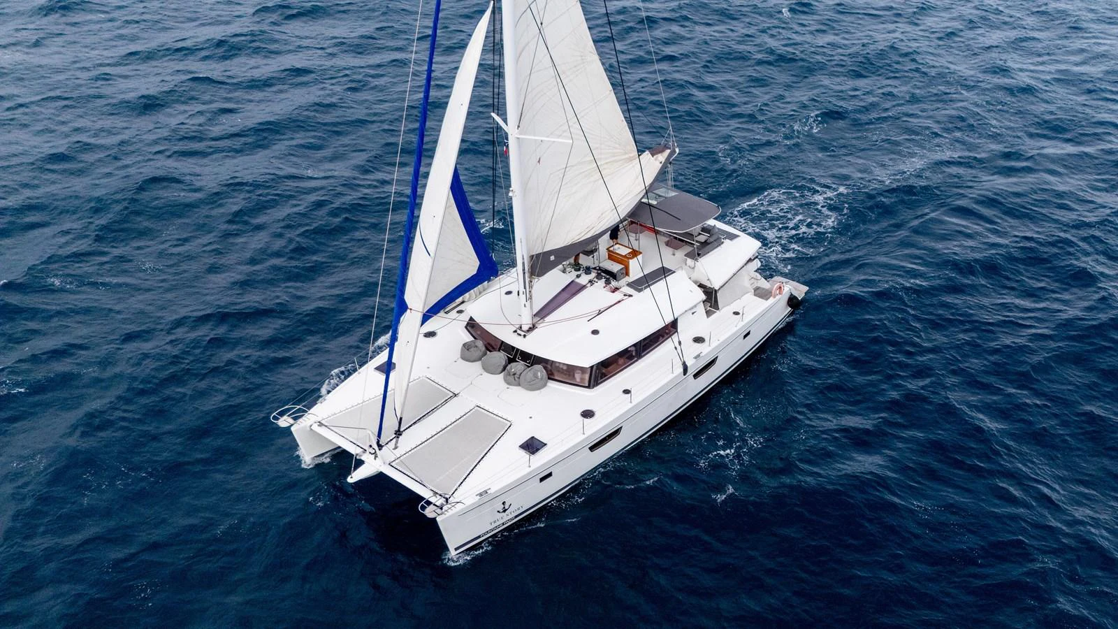 a white boat in the water aboard TRUE STORY Yacht for Sale