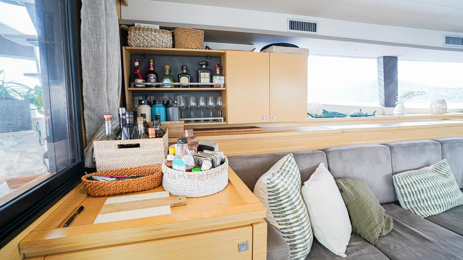 a room with a couch and a table with a basket and a window aboard TRUE STORY Yacht for Sale