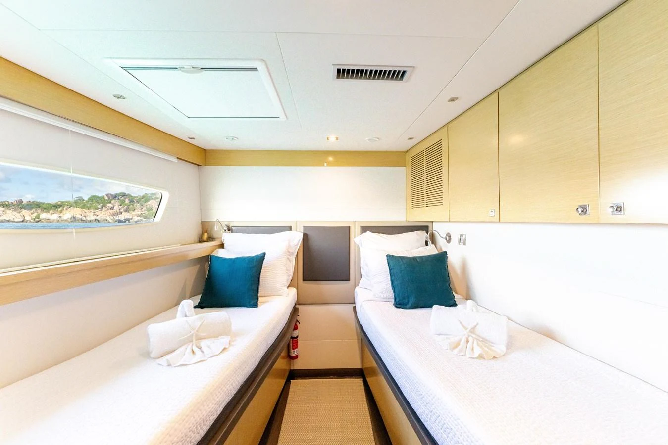 a room with beds and a window aboard TRUE STORY Yacht for Sale