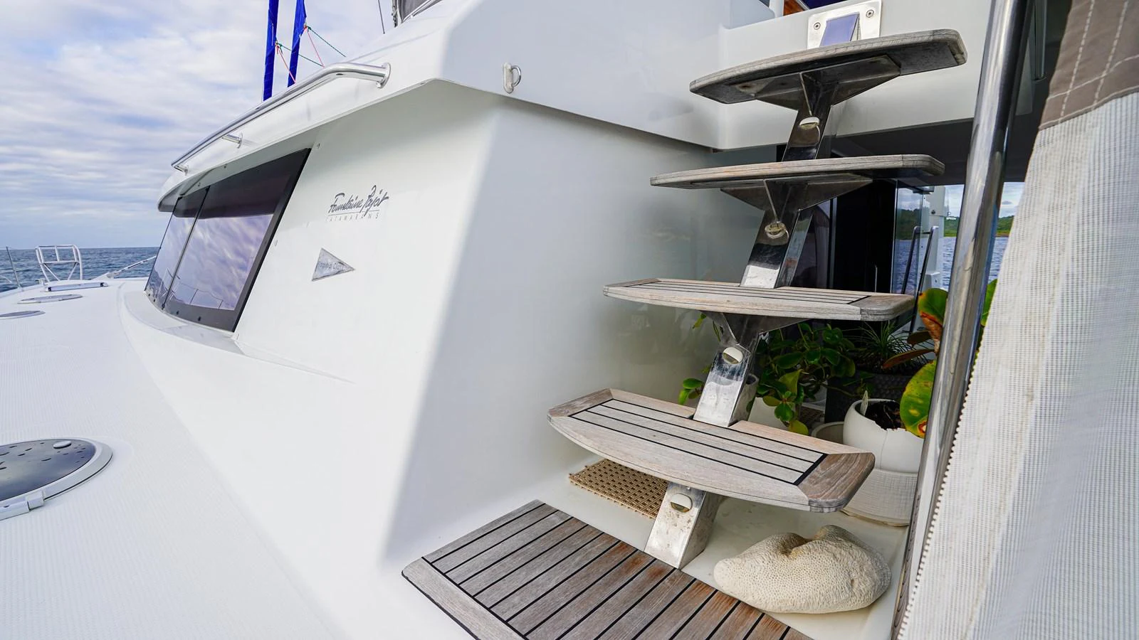 a white boat with a wooden deck aboard TRUE STORY Yacht for Sale