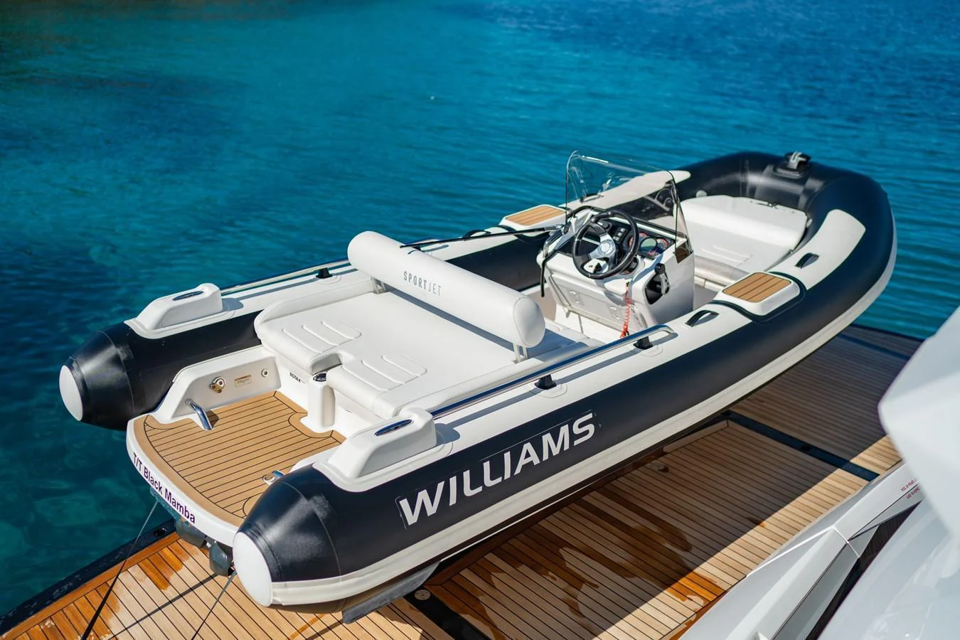 A sleek and modern tender is docked on a wooden platform, ready for use. aboard BLACK MAMBA Yacht for Sale