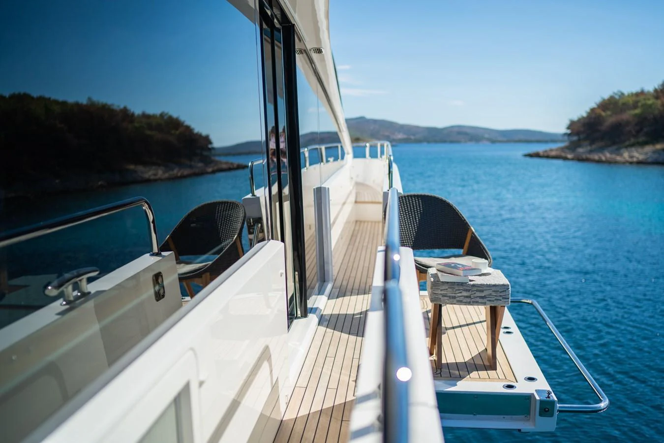 The side deck offers a serene spot with comfortable seating and stunning ocean views. aboard BLACK MAMBA Yacht for Sale