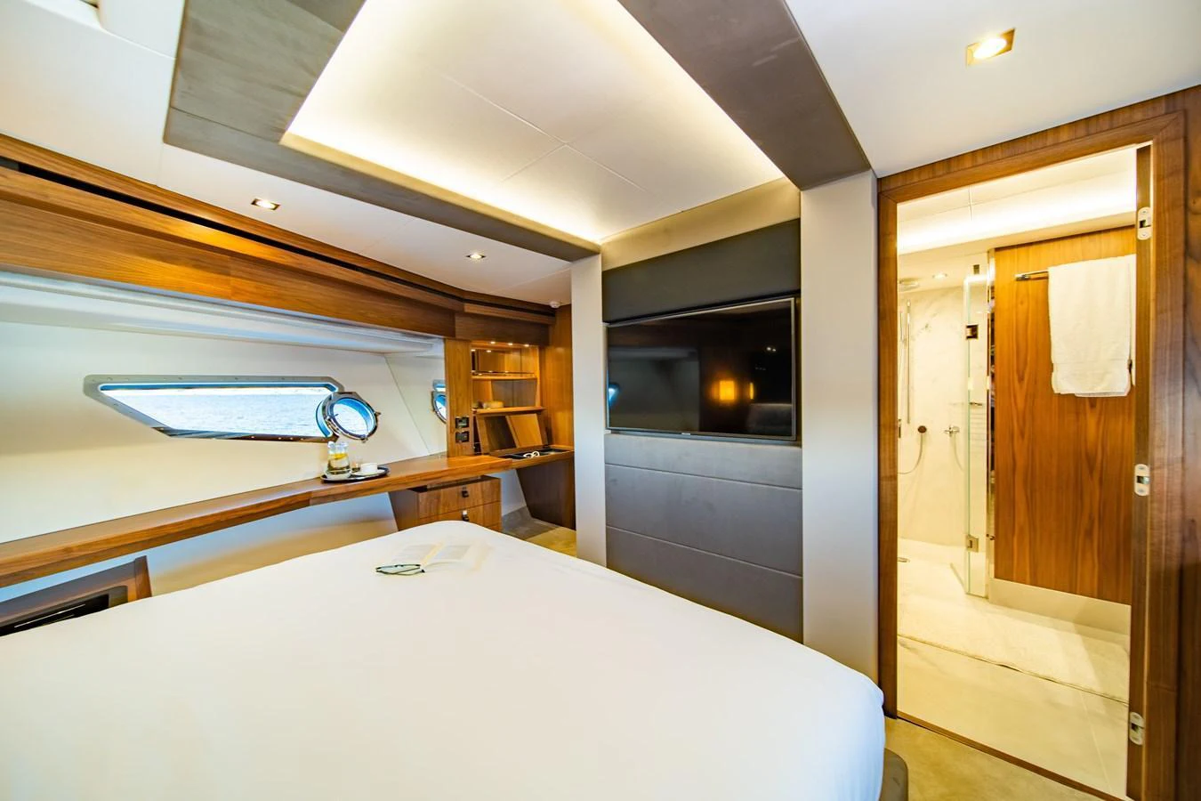 The stateroom features a luxurious bed, a large TV, and an ensuite bathroom with modern finishes. aboard BLACK MAMBA Yacht for Sale