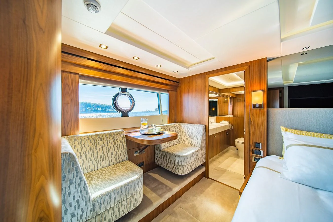The yacht's interior features a cozy dining area with a view of the sea through a large window. aboard BLACK MAMBA Yacht for Sale