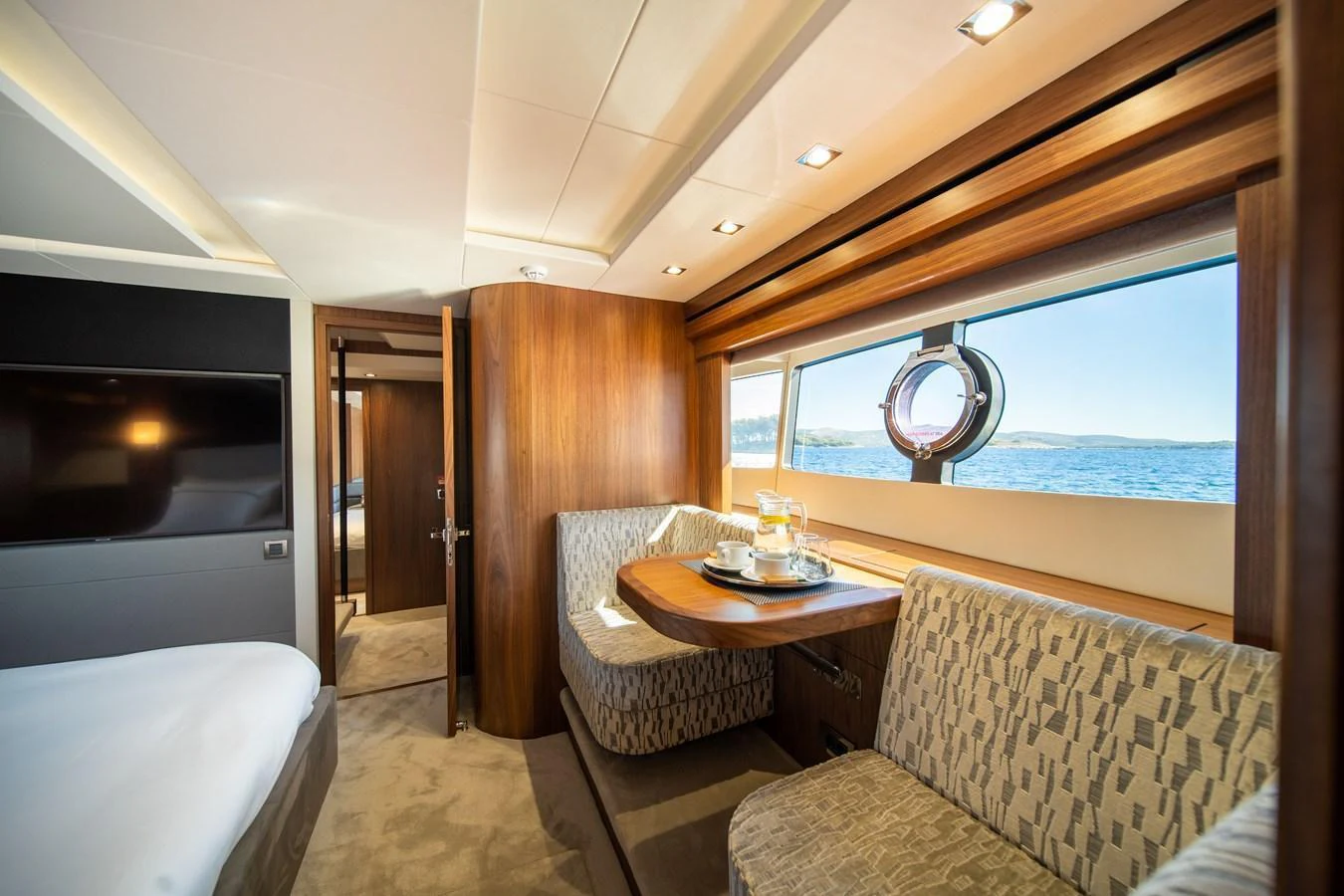 The salon features elegant wood paneling, plush seating, and large windows offering stunning sea views. aboard BLACK MAMBA Yacht for Sale