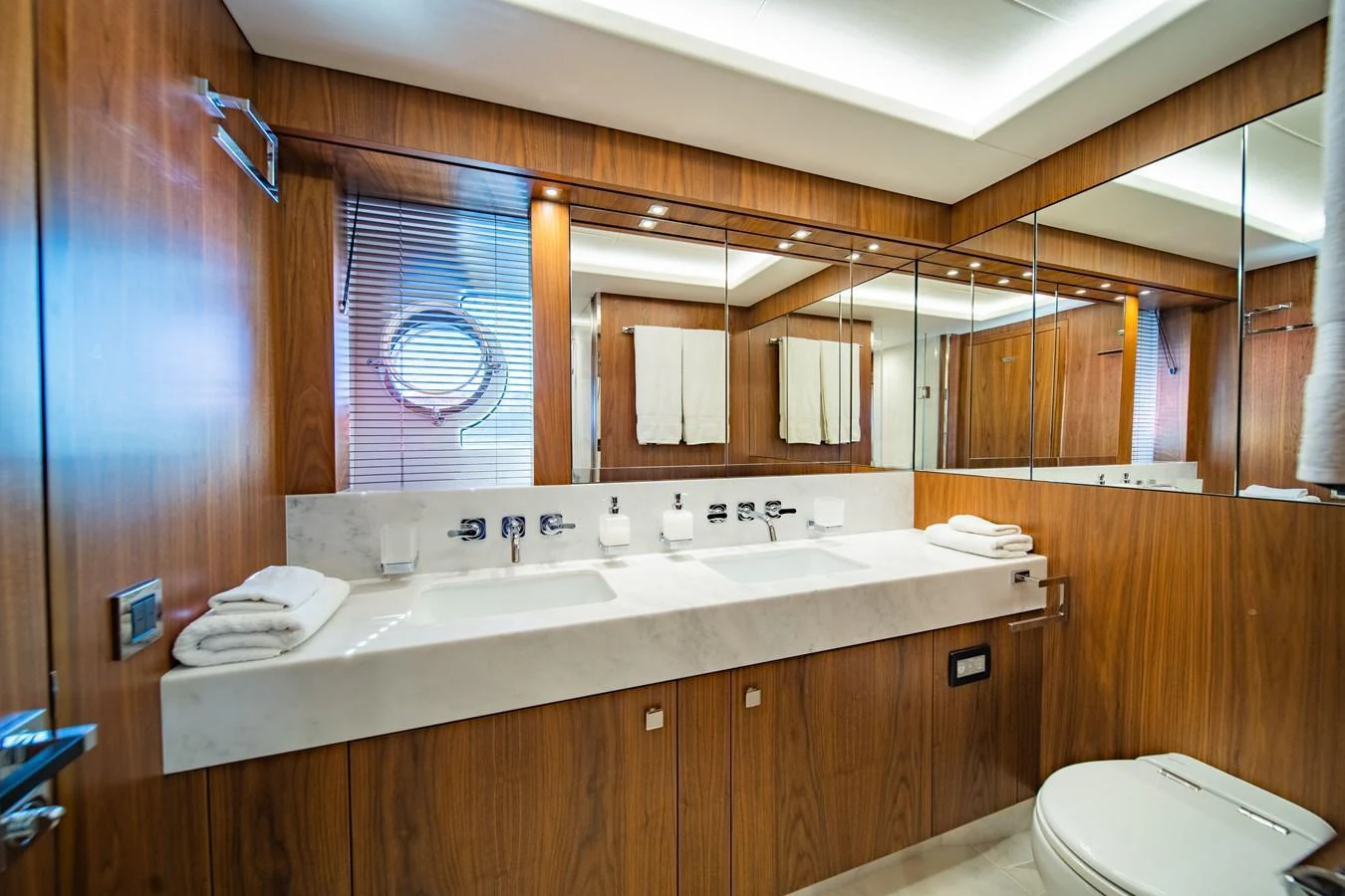 The yacht's bathroom features elegant wood paneling and modern fixtures. aboard BLACK MAMBA Yacht for Sale