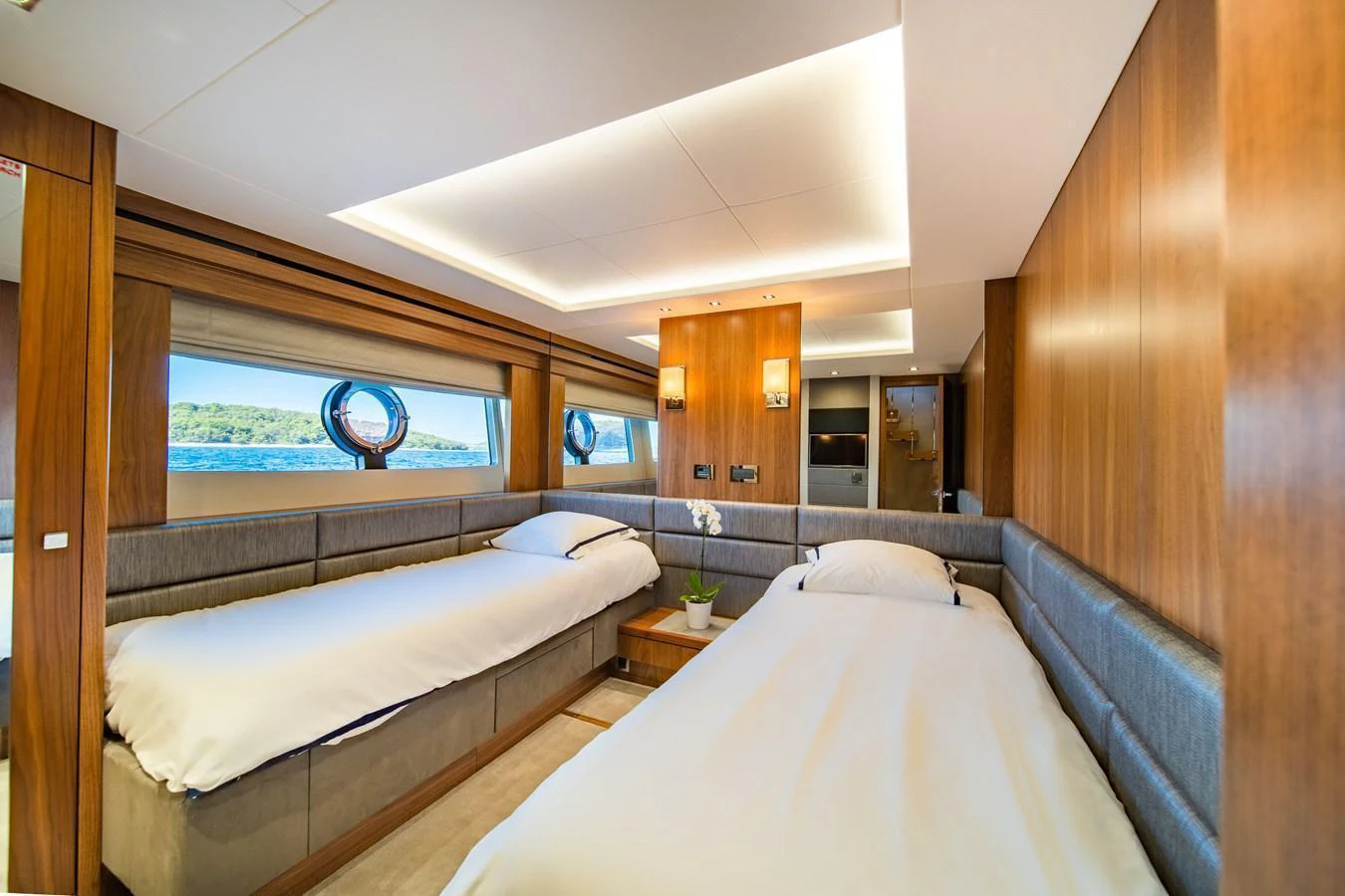 The twin stateroom offers a serene and comfortable retreat with ample natural light and elegant wood finishes. aboard BLACK MAMBA Yacht for Sale