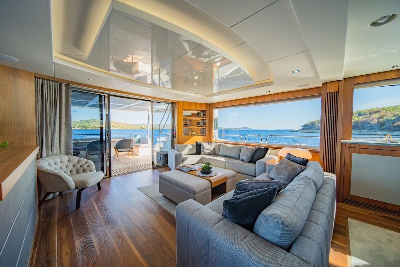 The yacht's salon features plush seating, elegant wood finishes, and expansive windows offering stunning sea views. aboard BLACK MAMBA Yacht for Sale