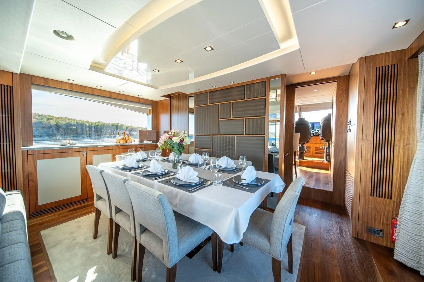 The yacht's dining area features a beautifully set table with elegant decor and ample natural light. aboard BLACK MAMBA Yacht for Sale