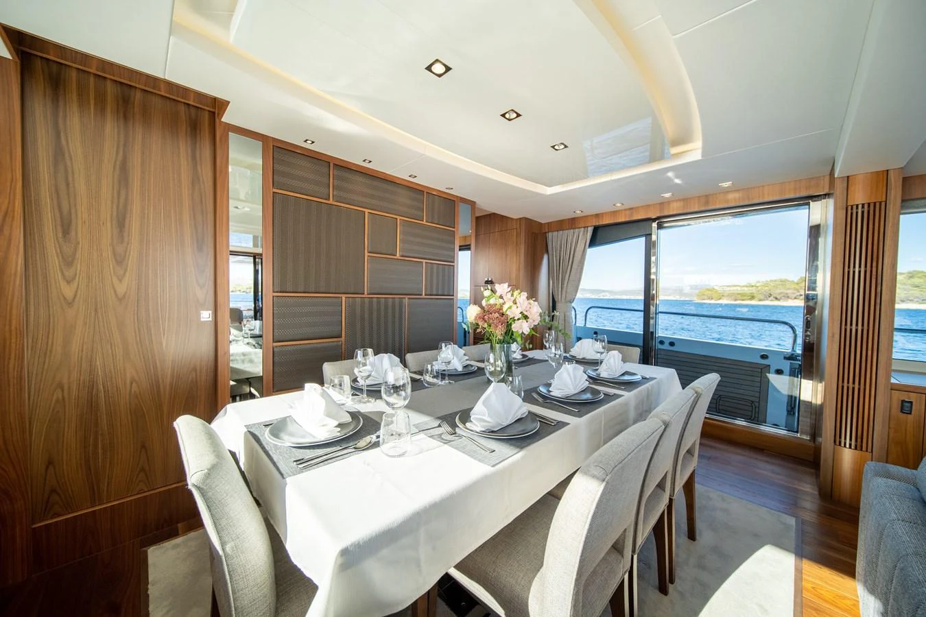 The yacht's dining area features elegant table settings and a panoramic view of the sea. aboard BLACK MAMBA Yacht for Sale