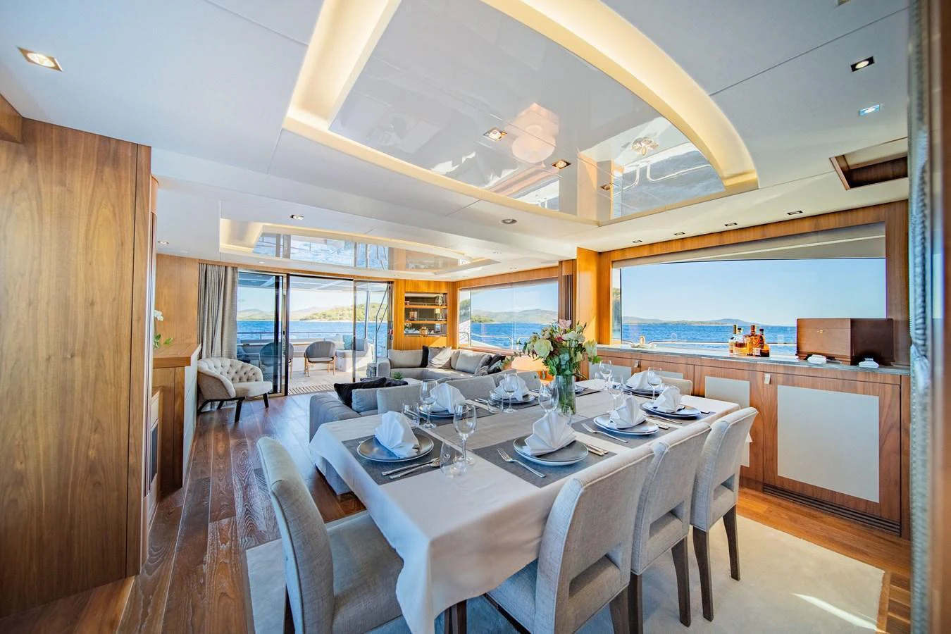 The yacht's dining area features elegant table settings and expansive windows offering stunning sea views. aboard BLACK MAMBA Yacht for Sale