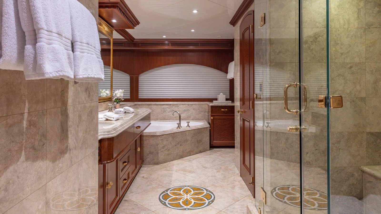 The yacht's bathroom features elegant wood accents, a spacious tub, and luxurious marble finishes. aboard RELENTLESS Yacht for Sale