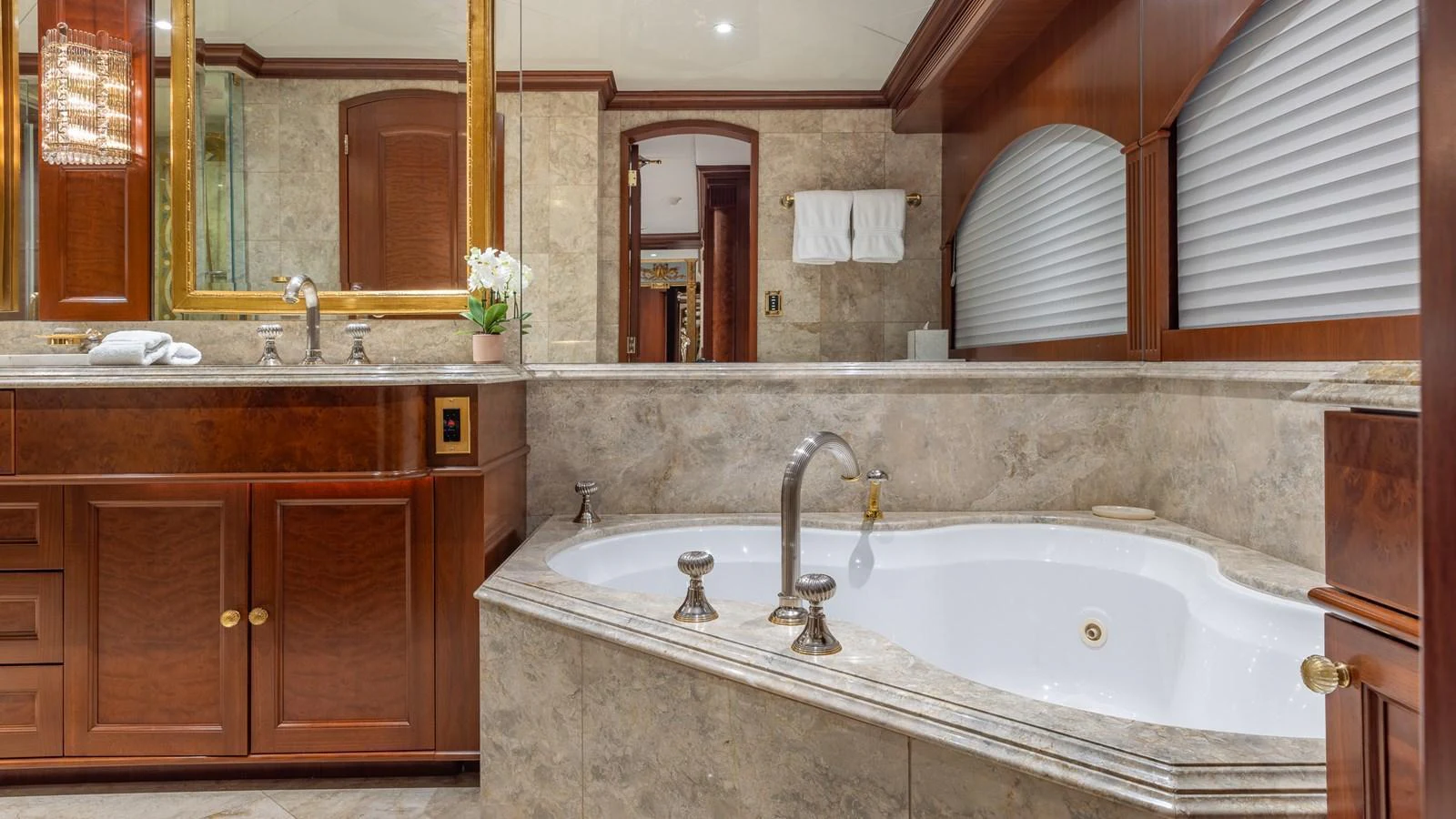 The yacht's bathroom features luxurious marble finishes and elegant wooden cabinetry. aboard RELENTLESS Yacht for Sale