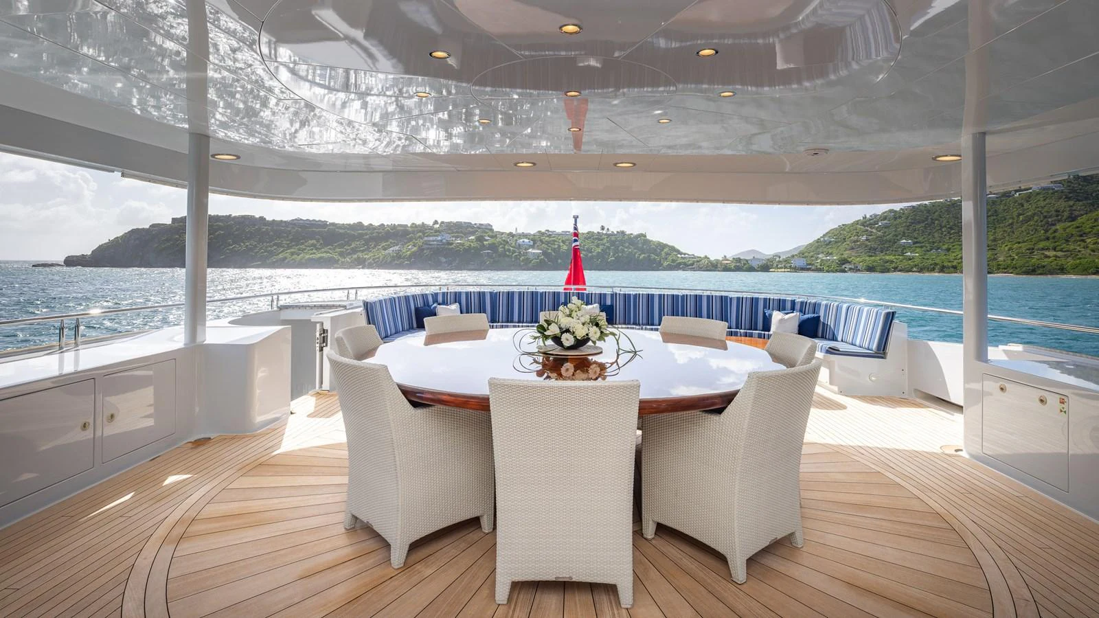 The aft deck features a spacious dining area with a large round table and comfortable seating, perfect for enjoying meals with a view. aboard RELENTLESS Yacht for Sale