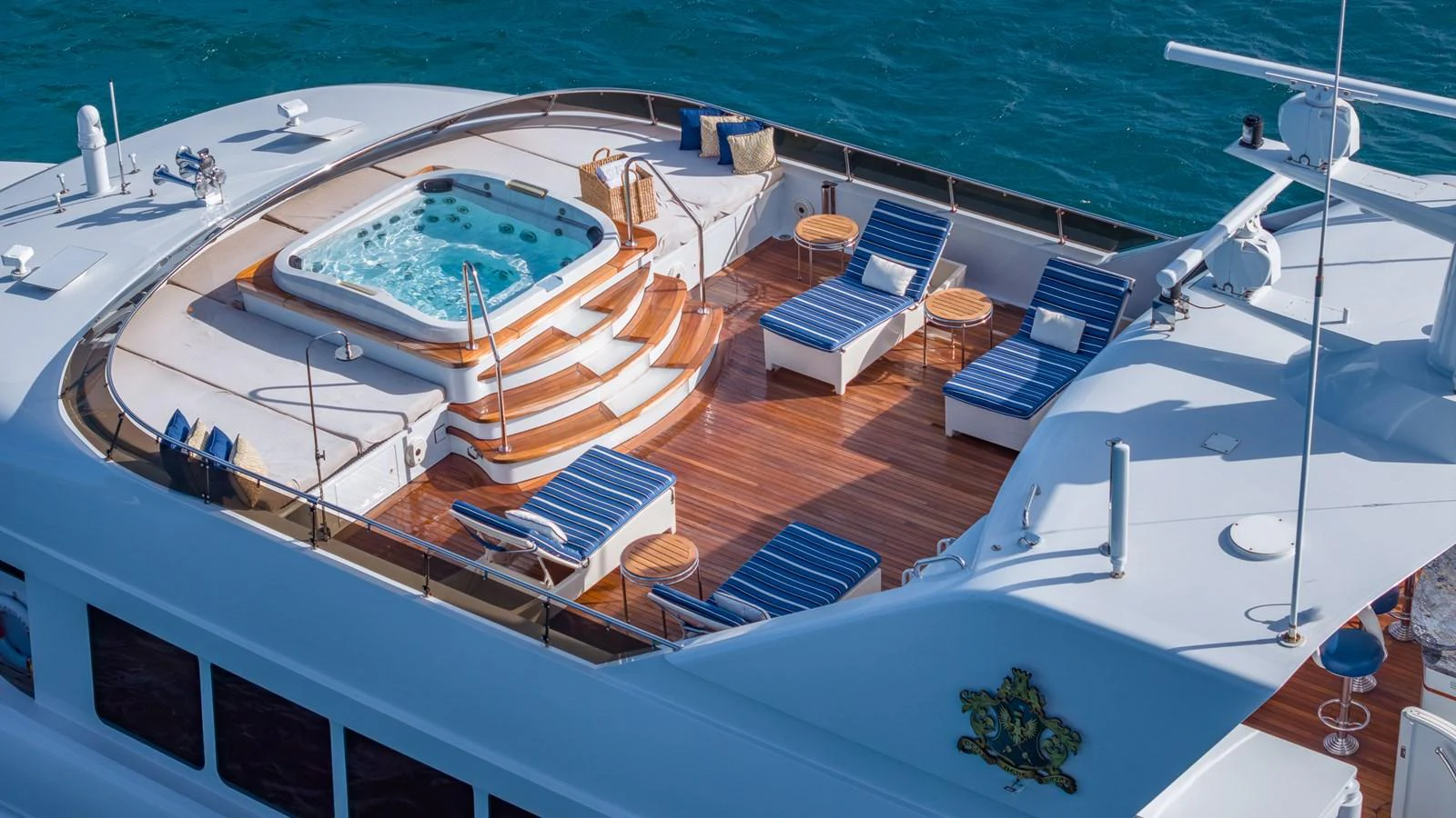 The sundeck features a luxurious hot tub surrounded by comfortable lounge seating and wooden decking. aboard RELENTLESS Yacht for Sale