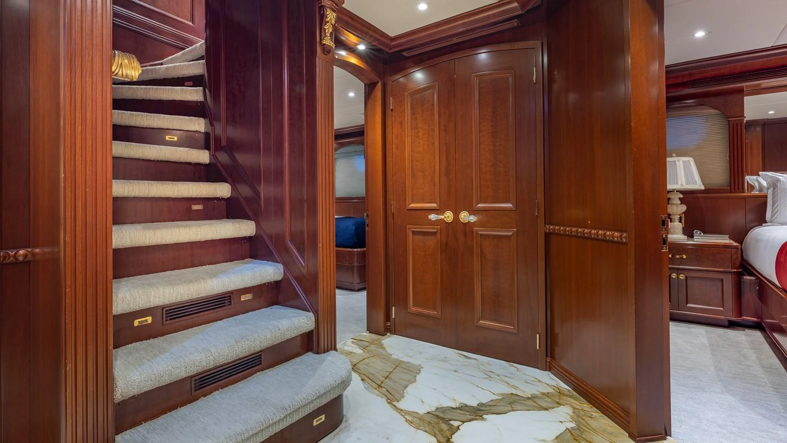 The yacht's interior features a luxurious wooden staircase and elegant doors, leading to a cozy and refined living space. aboard RELENTLESS Yacht for Sale