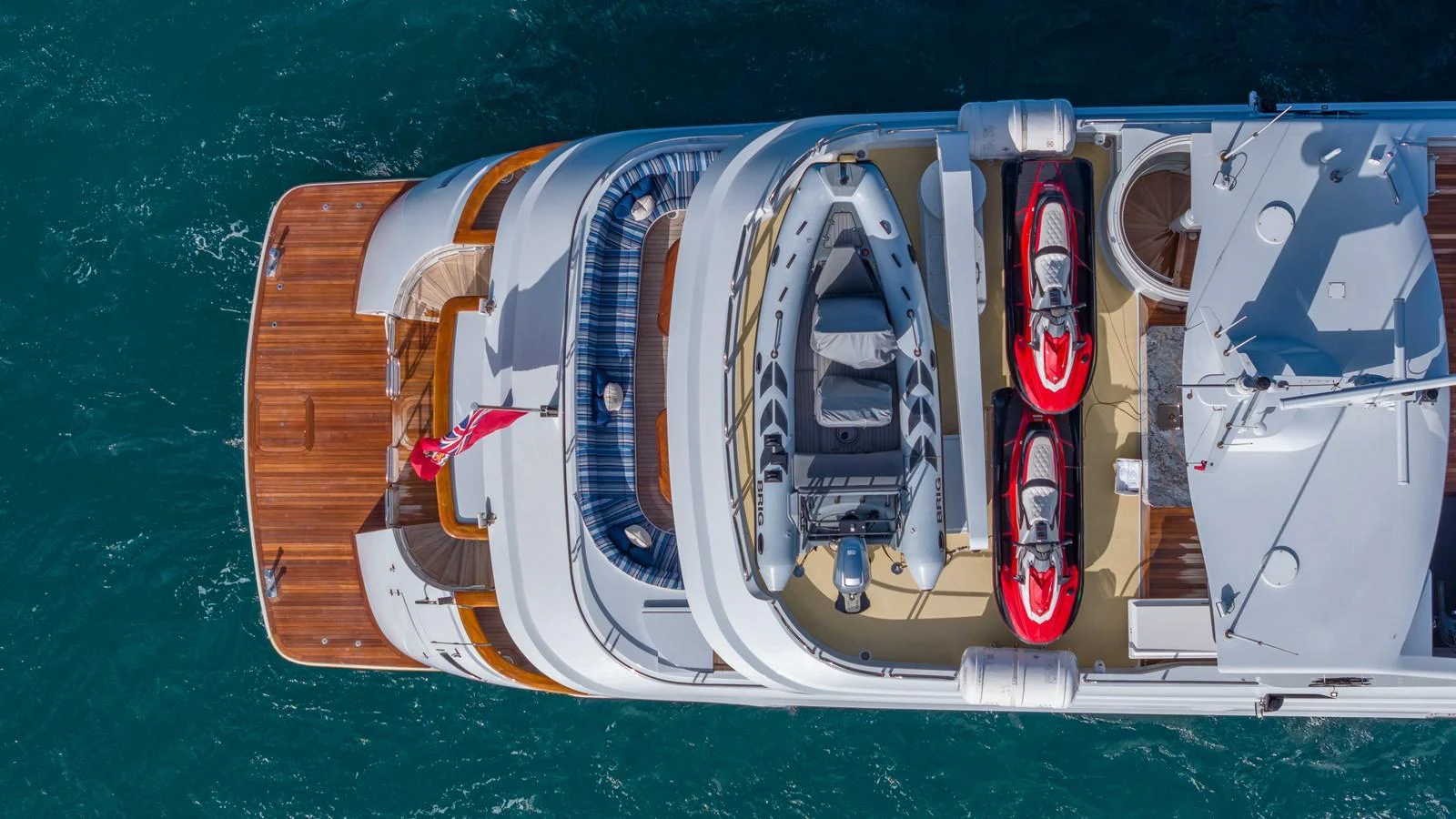 Aerial view of a yacht's sundeck featuring a tender and jet skis. aboard RELENTLESS Yacht for Sale