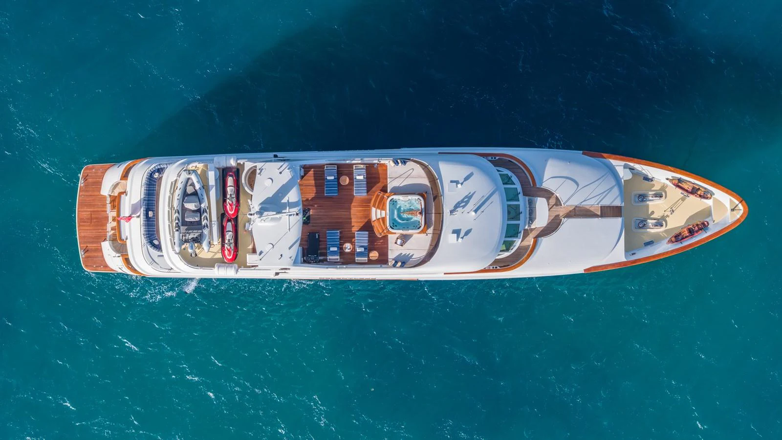 A stunning aerial view of a luxurious yacht cruising on clear blue waters. aboard RELENTLESS Yacht for Sale
