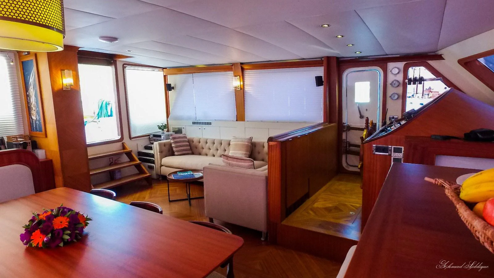 The yacht's salon features a cozy seating area with a plush sofa and a dining table, creating a warm and inviting atmosphere. aboard PAPA JOE Yacht for Sale