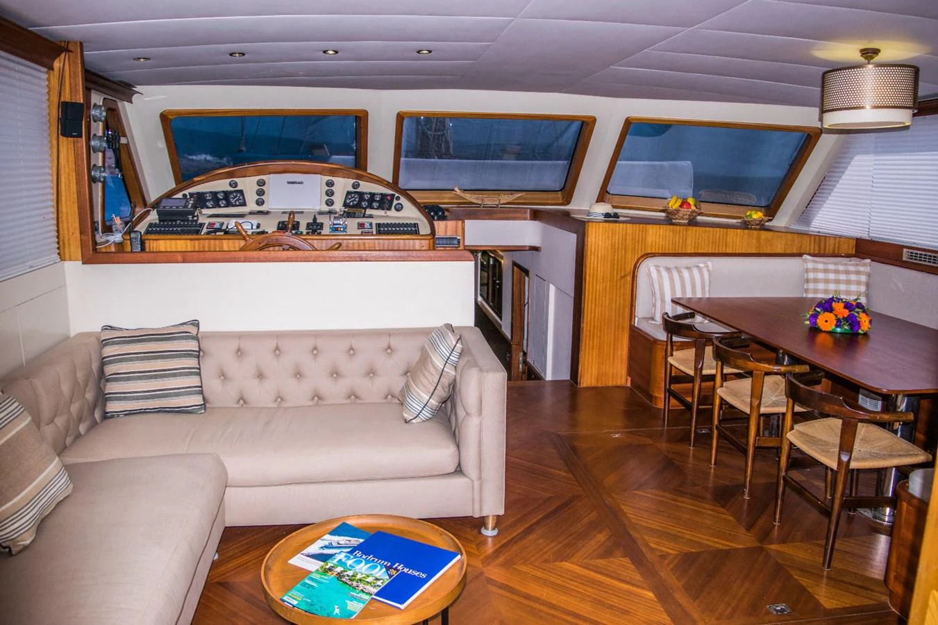 The yacht's salon features a comfortable seating area, a dining table, and a well-equipped helm station. aboard PAPA JOE Yacht for Sale