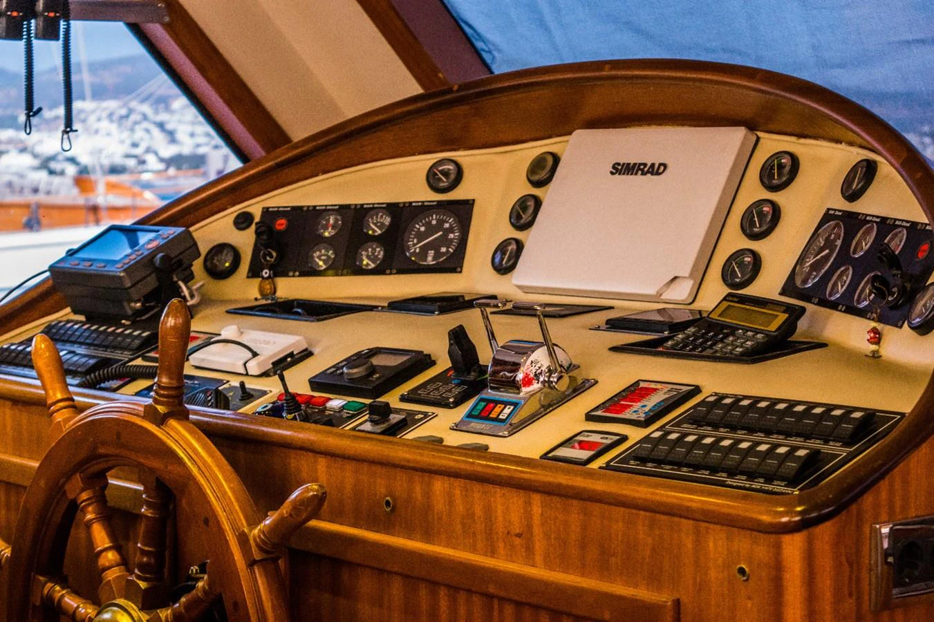 The helm station features a classic wooden wheel and an array of modern navigation instruments. aboard PAPA JOE Yacht for Sale