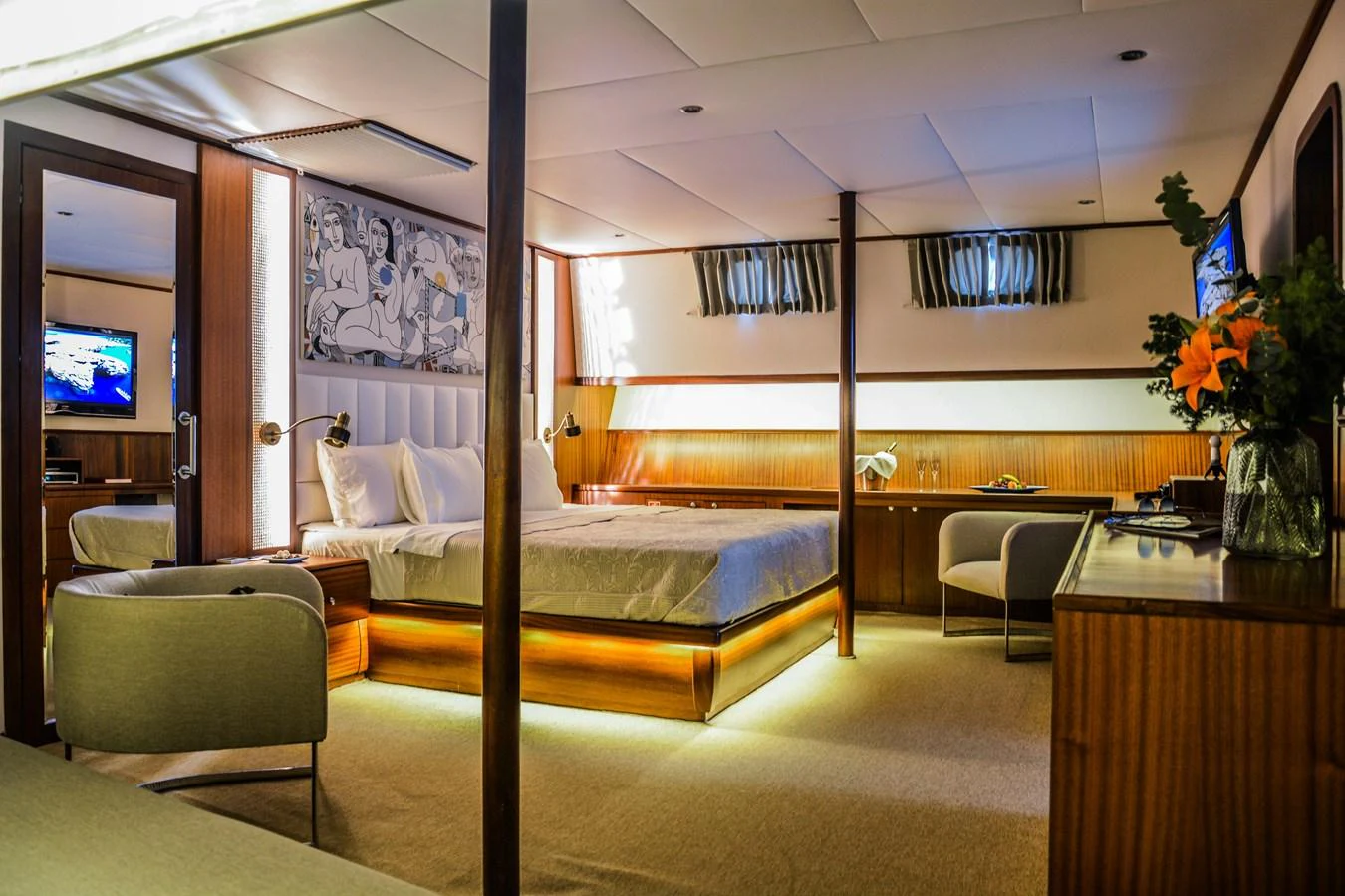 The master stateroom features a luxurious bed, elegant furnishings, and ambient lighting. aboard PAPA JOE Yacht for Sale