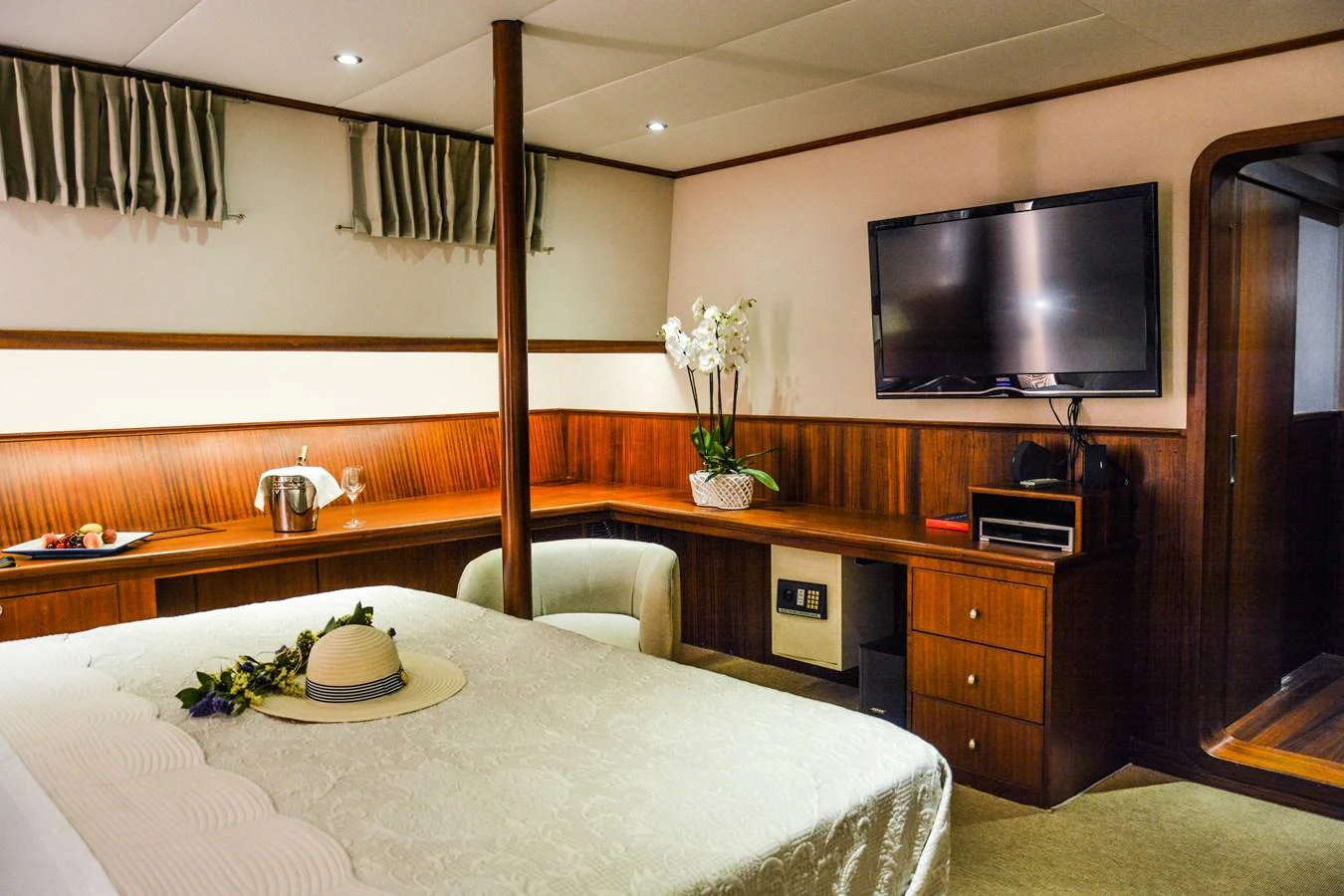 The stateroom features a cozy bed, a flat-screen TV, and elegant wooden furnishings. aboard PAPA JOE Yacht for Sale