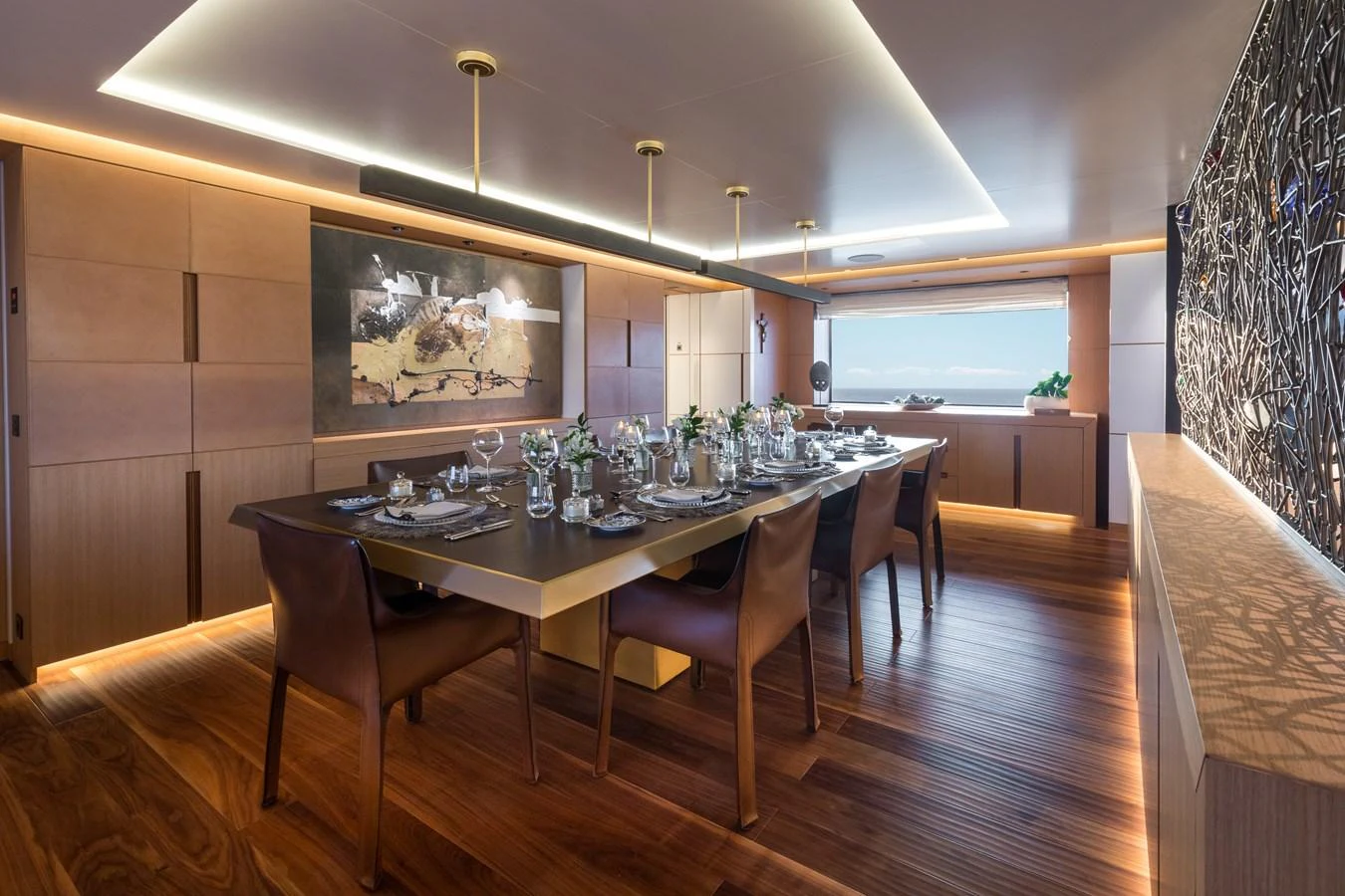 The yacht's dining area features a sophisticated setting with a large table and elegant decor. aboard ALCHEMIST Yacht for Sale