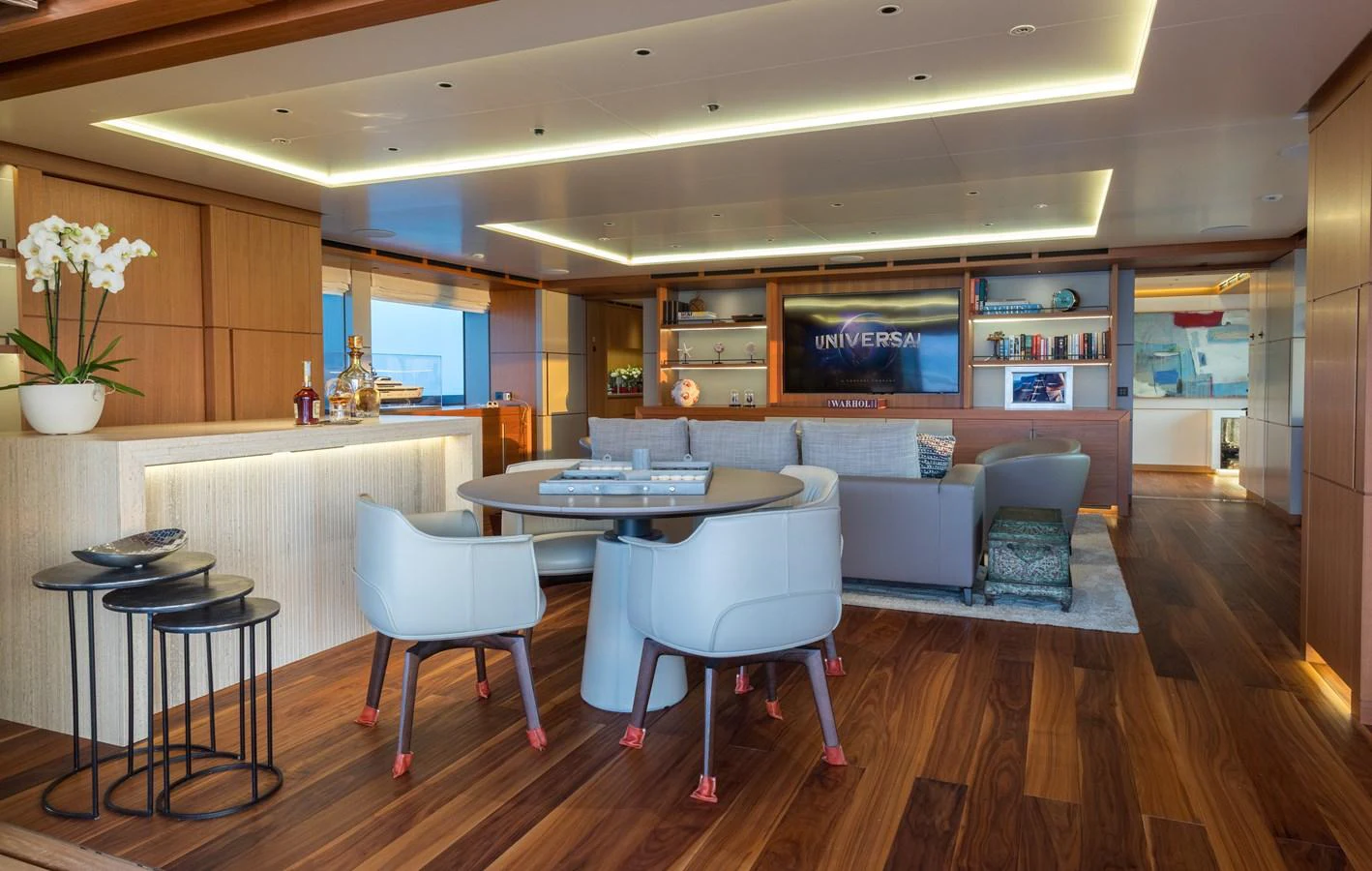 The salon features elegant seating, a dining area, and modern decor with warm wood tones. aboard ALCHEMIST Yacht for Sale