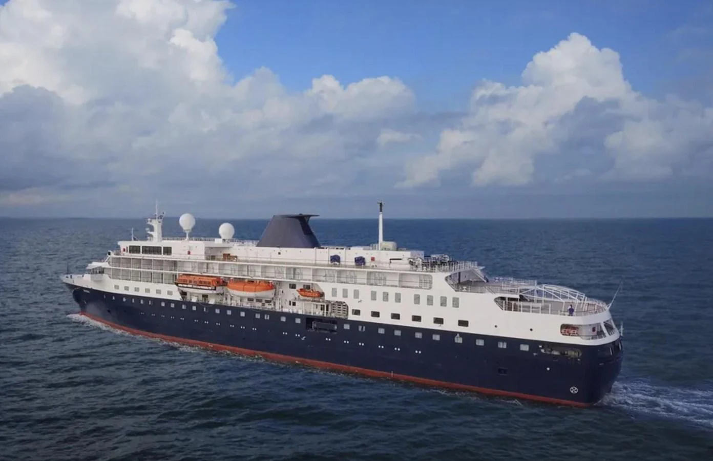 A majestic yacht cruises through the open sea under a partly cloudy sky. aboard MINERVA Yacht for Sale