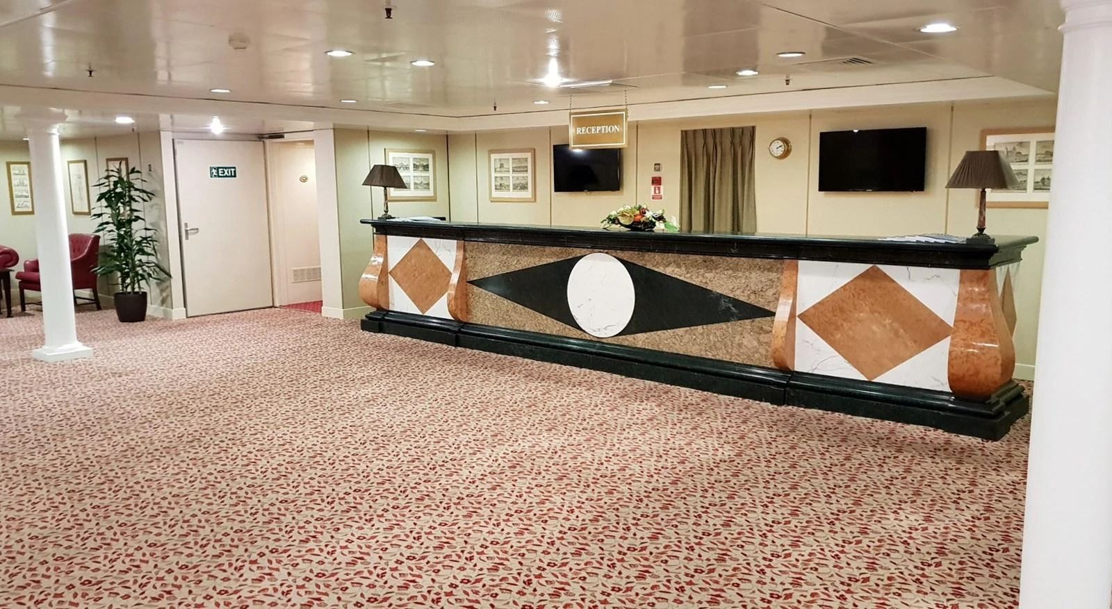 The yacht's reception area features a stylish desk with geometric patterns and a spacious, carpeted floor. aboard MINERVA Yacht for Sale