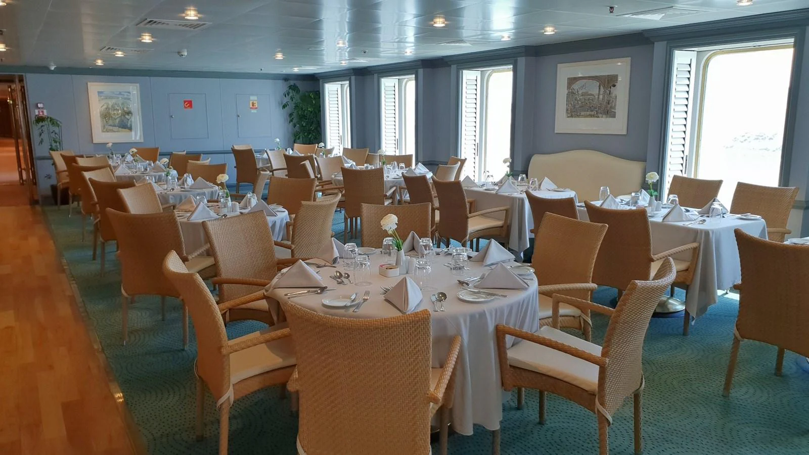 The yacht's dining area features elegantly set tables with comfortable seating and large windows offering natural light. aboard MINERVA Yacht for Sale