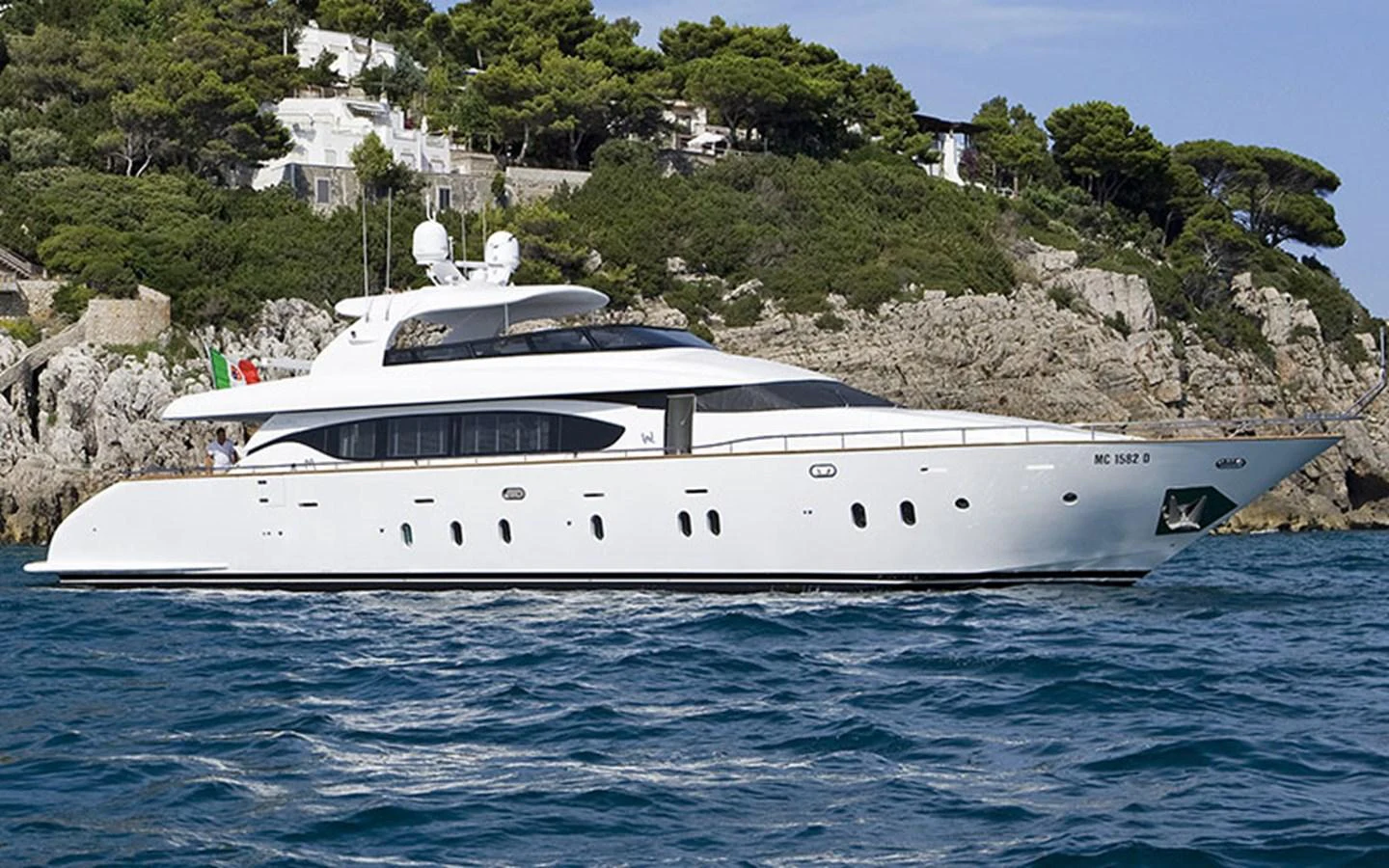 A sleek and elegant yacht cruising along a scenic coastline. aboard NIKCA Yacht for Sale
