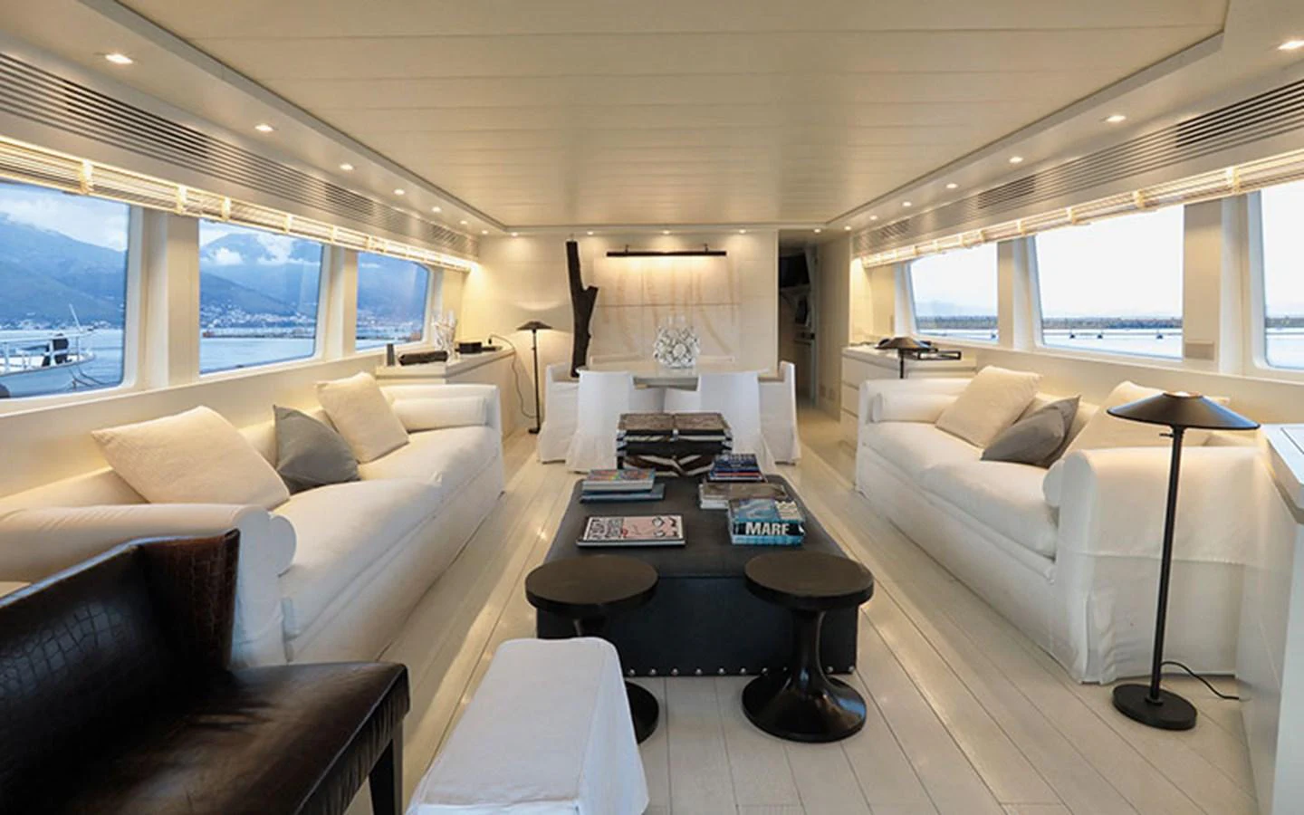 The salon features a spacious and elegantly designed seating area with large windows offering panoramic views. aboard NIKCA Yacht for Sale