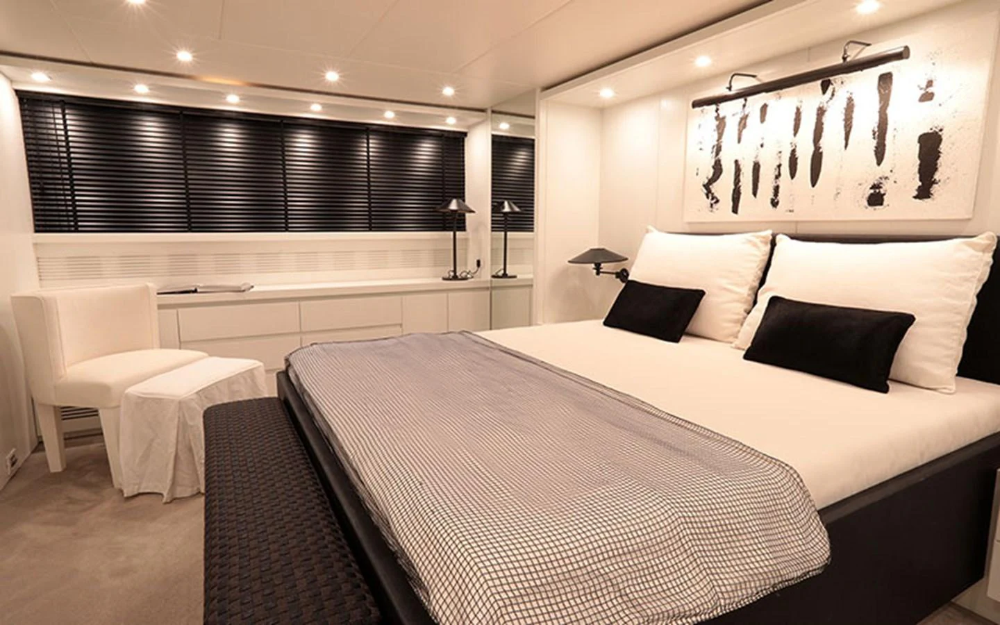 The stateroom features a luxurious bed with modern decor and ample lighting. aboard NIKCA Yacht for Sale