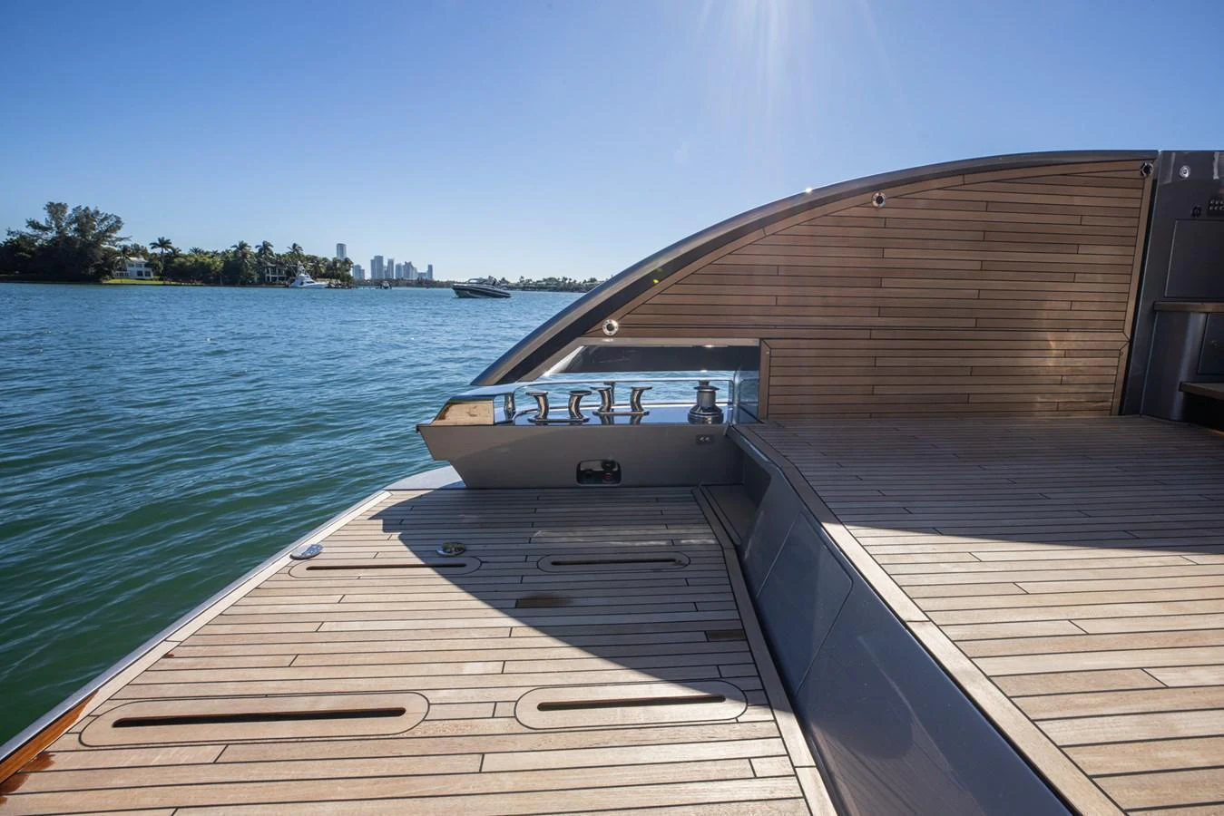 The yacht's aft deck features a spacious and elegant teak layout with a serene water backdrop. aboard CIAO Yacht for Sale