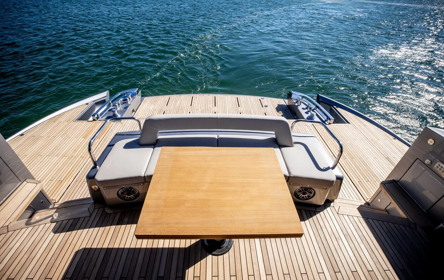 The aft deck features a sleek wooden table and comfortable seating, perfect for enjoying the ocean view. aboard CIAO Yacht for Sale