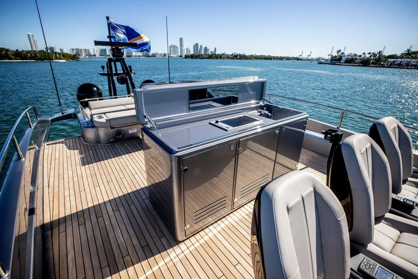 The flybridge offers a sleek outdoor kitchen area with a stunning view of the city skyline. aboard CIAO Yacht for Sale