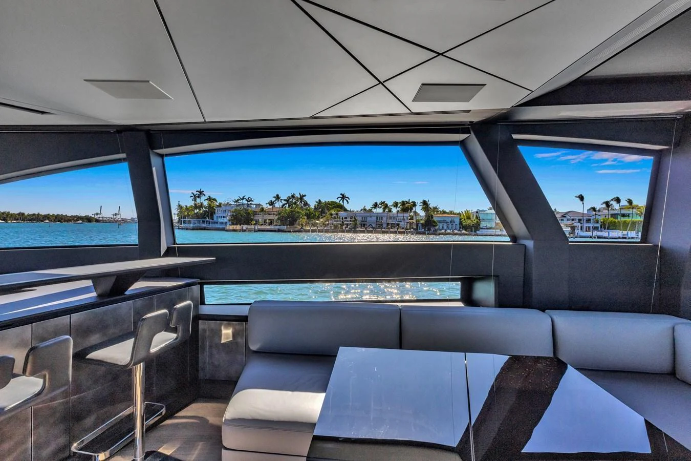 The salon offers a sleek and modern space with large windows providing stunning water views. aboard CIAO Yacht for Sale