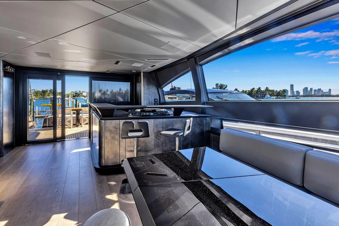 The salon features modern furnishings with expansive windows offering stunning views. aboard CIAO Yacht for Sale