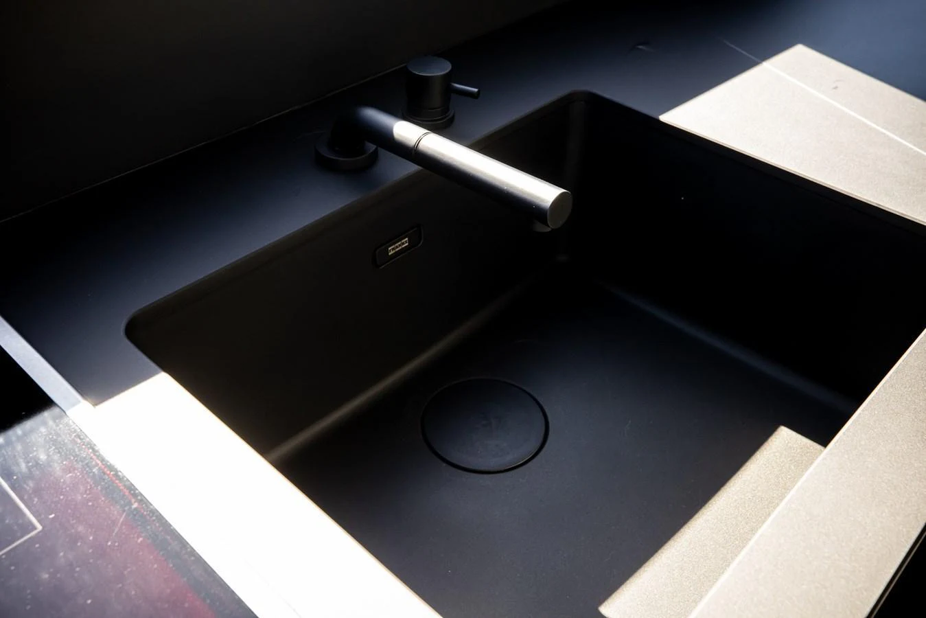 A sleek, modern black sink in the yacht's galley, illuminated by natural light. aboard CIAO Yacht for Sale