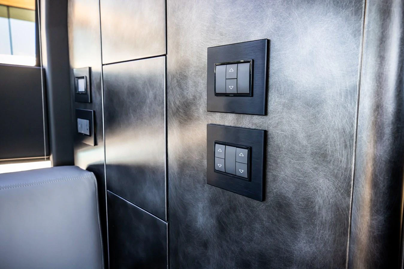 A close-up view of modern control switches on a sleek wall panel. aboard CIAO Yacht for Sale