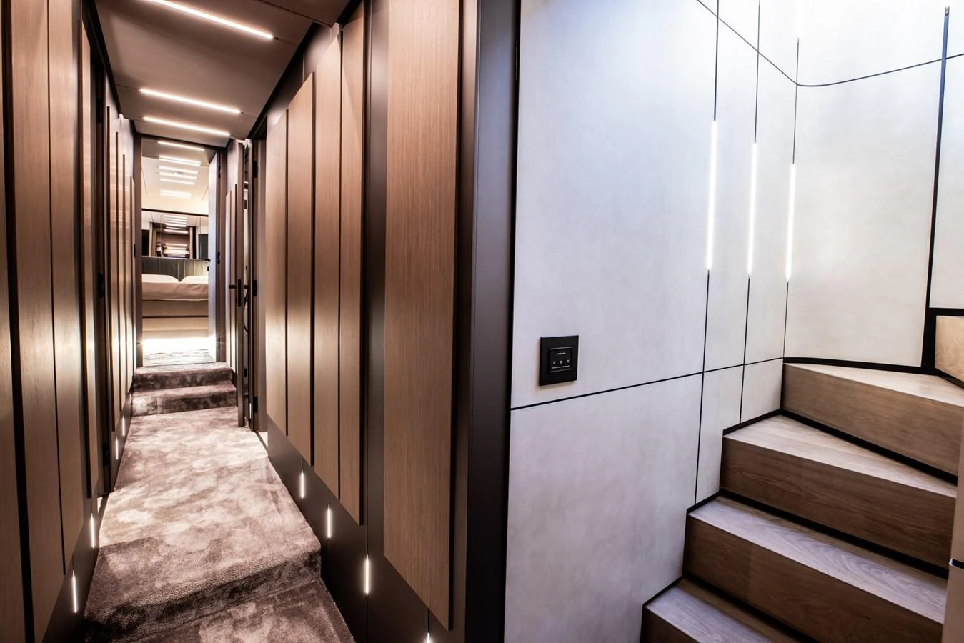 A modern hallway with sleek wooden paneling and a staircase leading to the upper deck. aboard CIAO Yacht for Sale