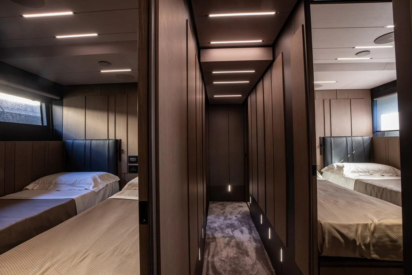 The stateroom features a modern design with twin beds and ambient lighting. aboard CIAO Yacht for Sale