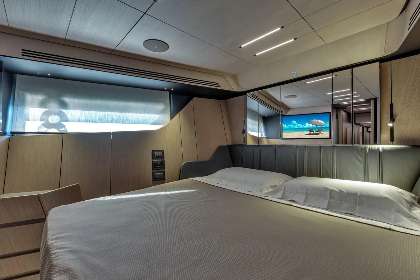 The stateroom features a luxurious bed with modern lighting and a serene ambiance. aboard CIAO Yacht for Sale