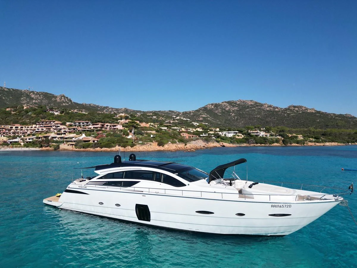 A sleek, modern yacht glides gracefully on turquoise waters with a scenic coastal backdrop. aboard THYKE III Yacht for Sale