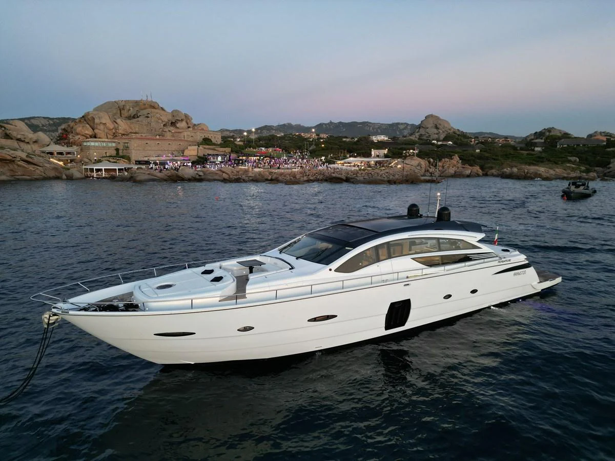 A sleek and modern yacht glides gracefully on calm waters near a rocky shoreline. aboard THYKE III Yacht for Sale